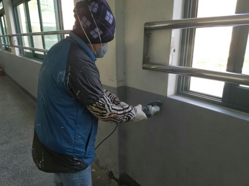 금속 난간 벽면에서 진행되는 표면 정리 작업