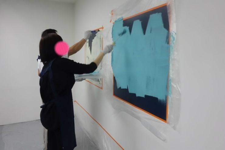 테이핑된 사각형 구역에 파란색 페인트를 칠하는 과정