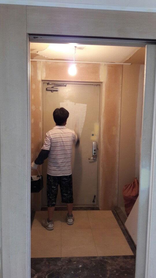 흰색 도배지와 타일 바닥이 보이는 복도 공정