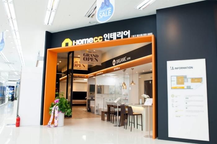 GRAND OPEN 표지판과 식물이 배치된 매장 입구