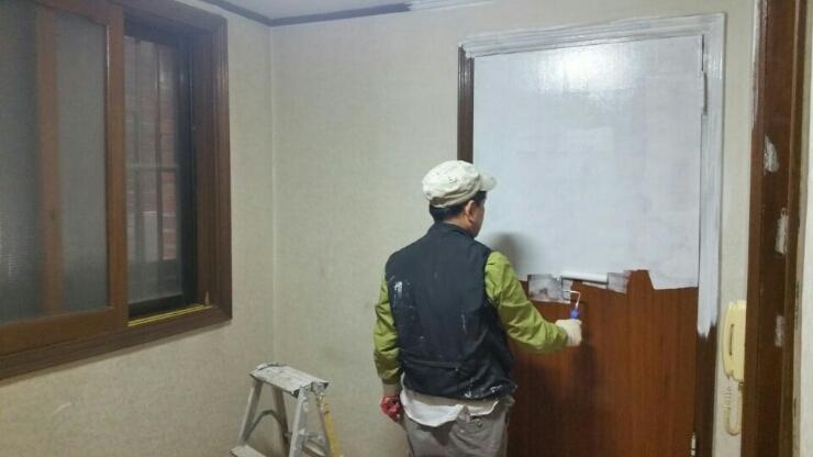 벽면과 문에 페인트를 칠하고 있는 작업 현장