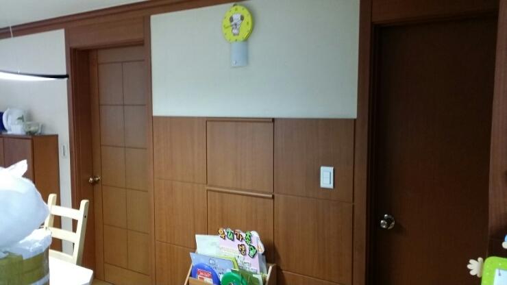 나무 패널과 흰색 벽면이 교차하는 실내 공간