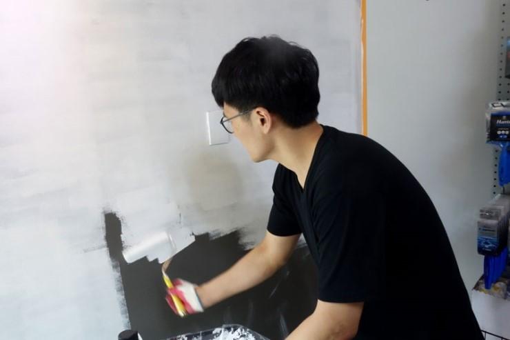 롤러를 이용해 벽면의 색상을 채워 나가는 모습