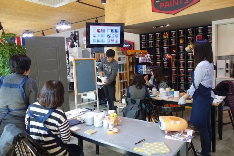 목재 마감 천장 아래 정렬된 페인트 통들