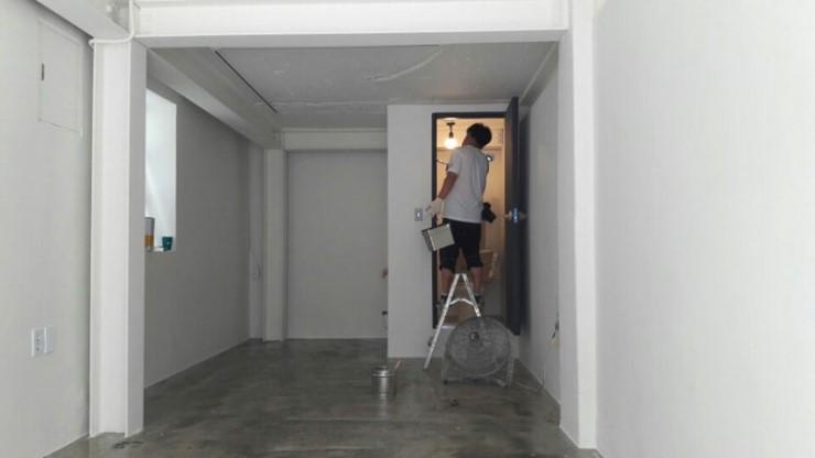 테이블 래터와 작업자가 배치된 흰 벽의 복도 공간