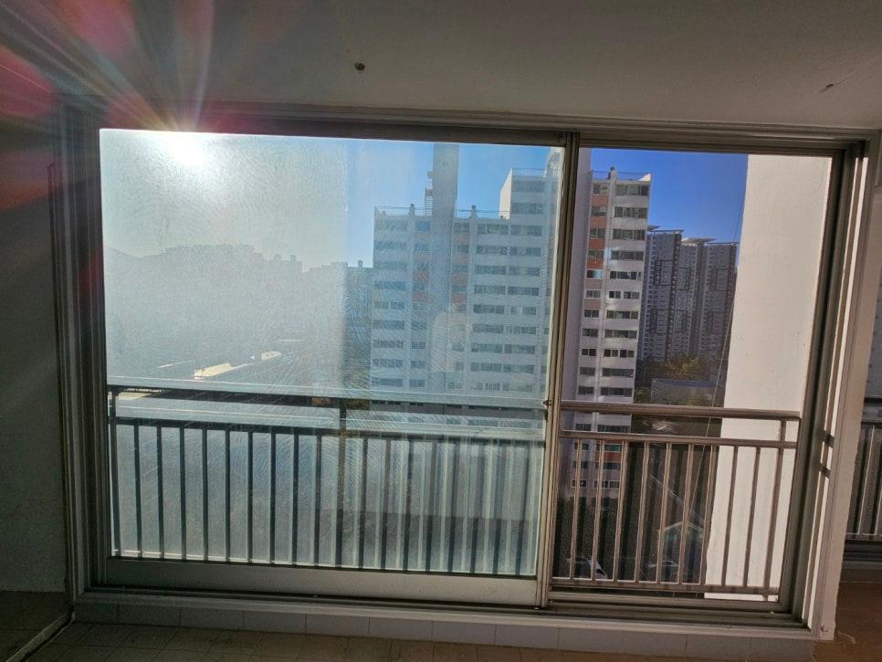 슬라이딩 창호가 설치된 발코니와 외부 건물 배경