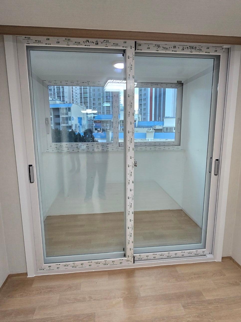 흰색 벽면과 유리 패널 창호가 맞닿은 실내 공간