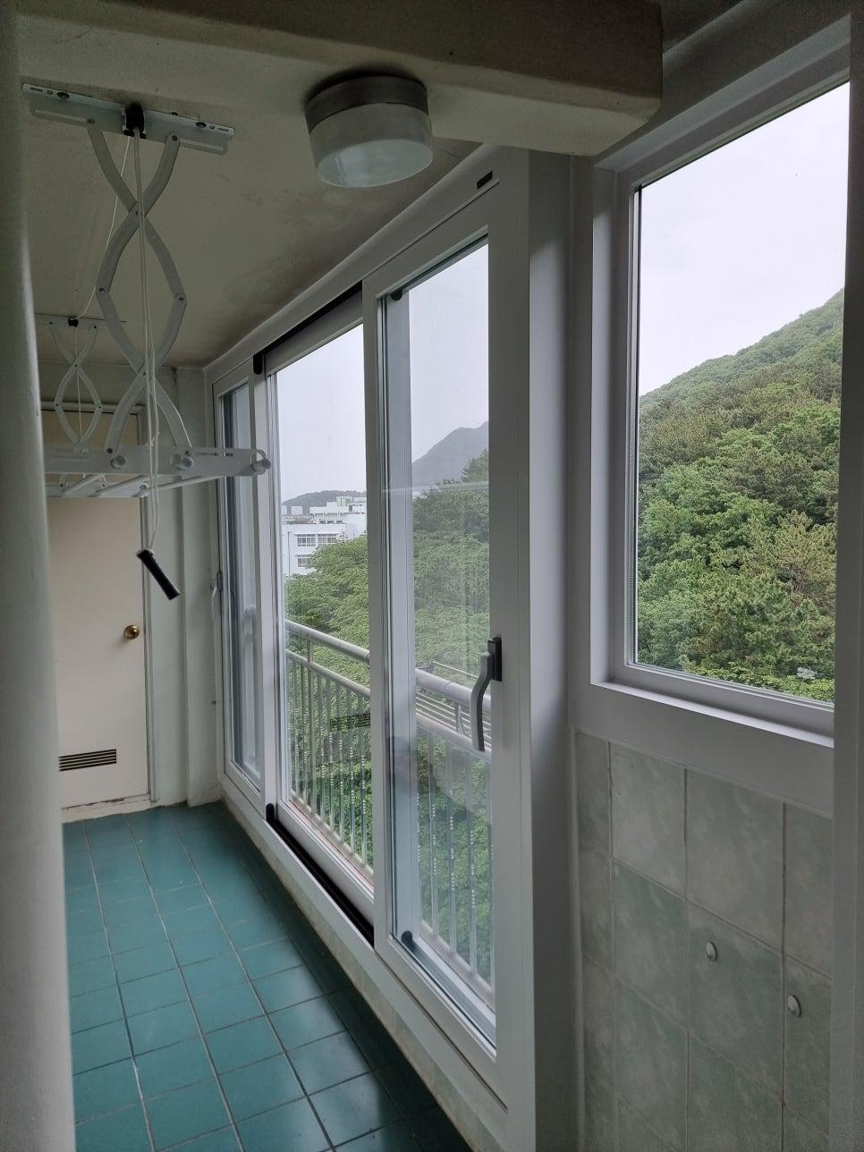 푸른 타일 바닥과 흰색 프레임이 설치된 발코니