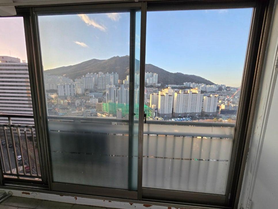 도시 풍경과 산이 배경으로 보이는 발코니 창호