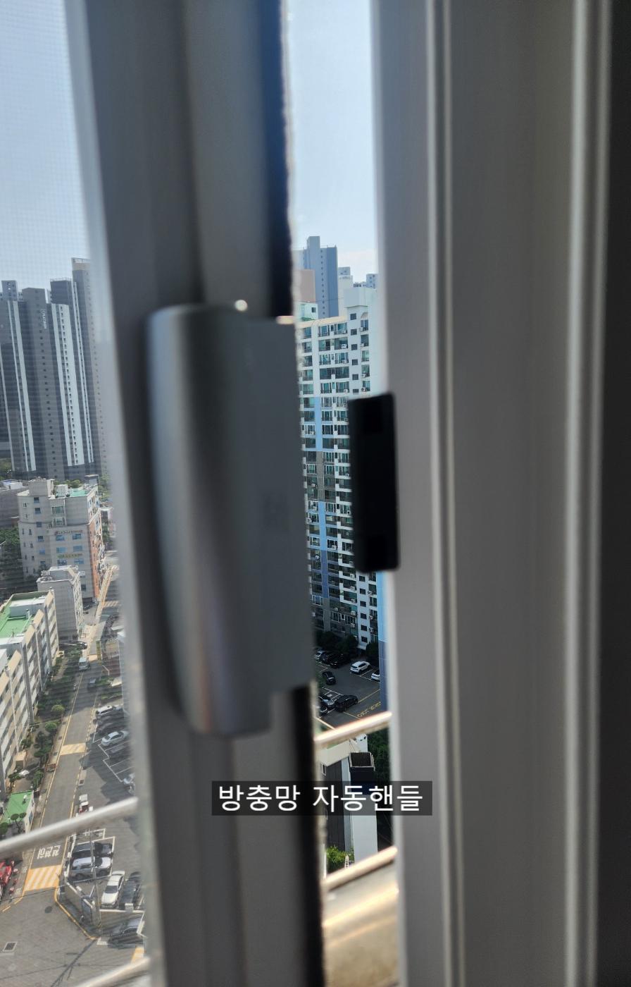 창호 외부에 설치된 자동핸들 부품의 근접 샷