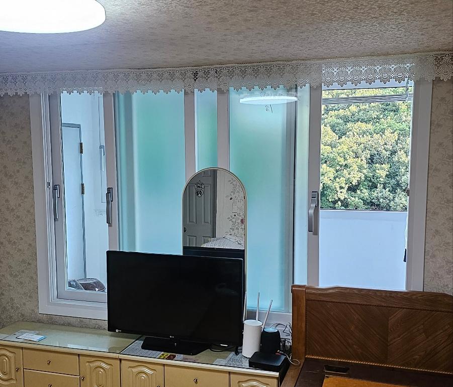 TV 캐비닛 위로 보이는 거실 창호 작업 과정