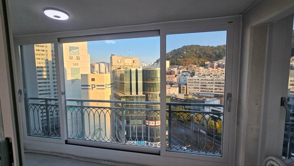 도시 풍경이 비치는 발코니 창호의 모습
