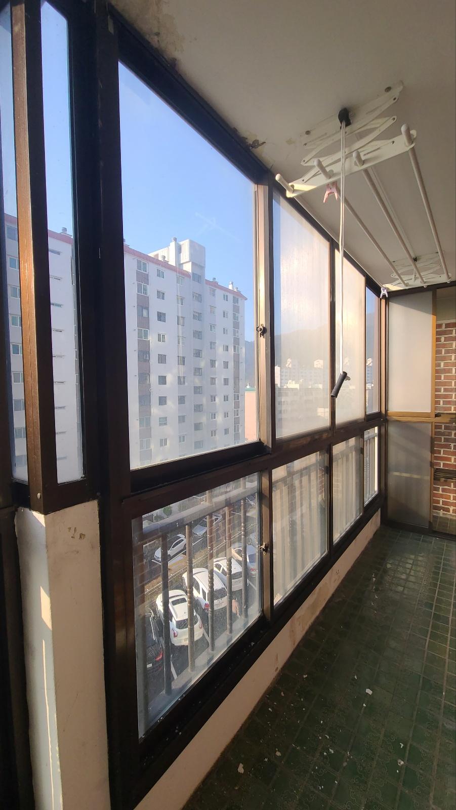 녹색 타일 바닥이 깔린 발코니의 기존 상태