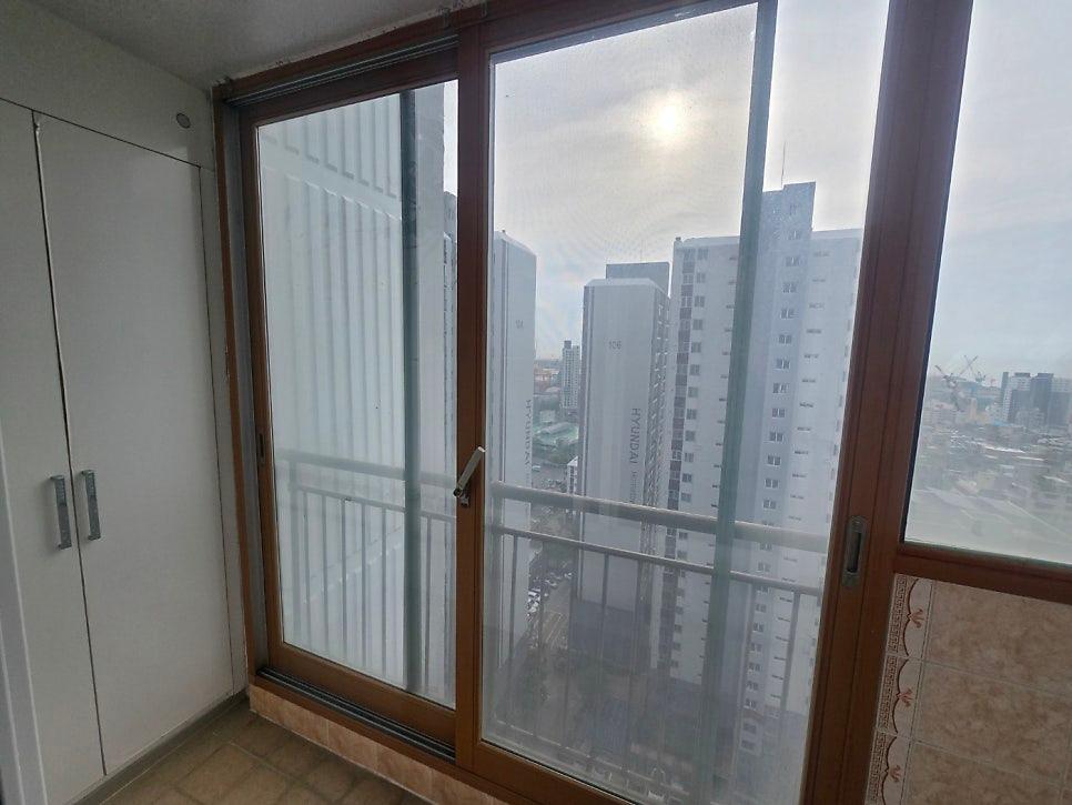 갈색 프레임과 흰 벽면이 보이는 발코니 시공 전 모습