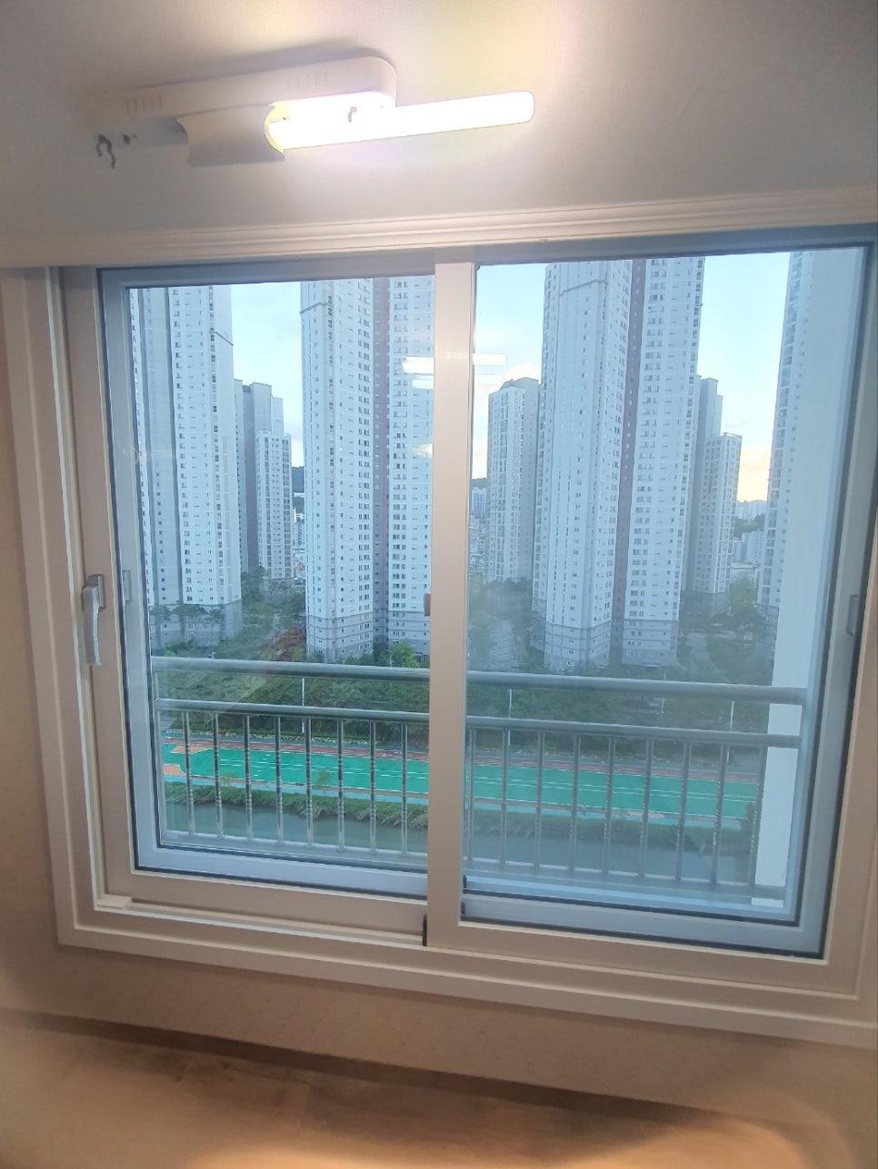 외부 건물 뷰가 보이는 실내 창문 근접 촬영샷