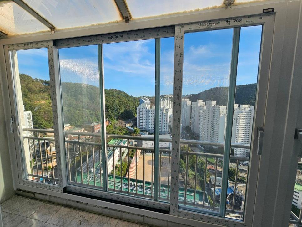 산과 아파트 배경이 보이는 투명 유리창 근접샷