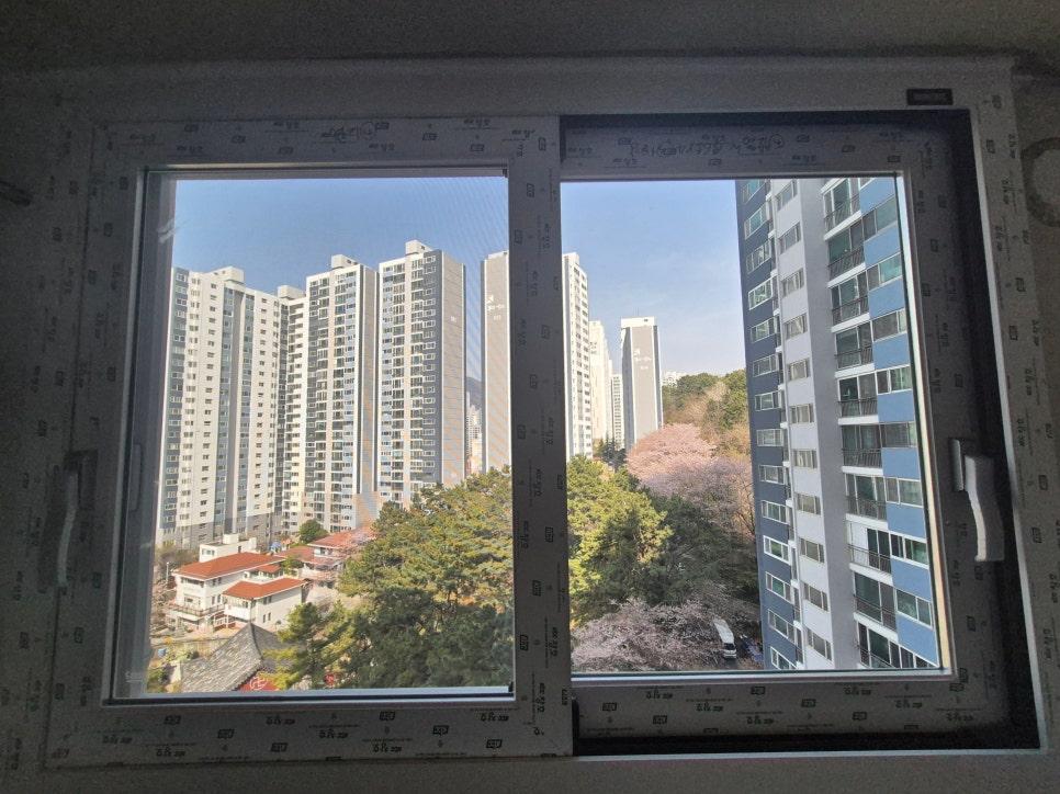 창밖으로 아파트 단지와 나무가 보이는 풍경