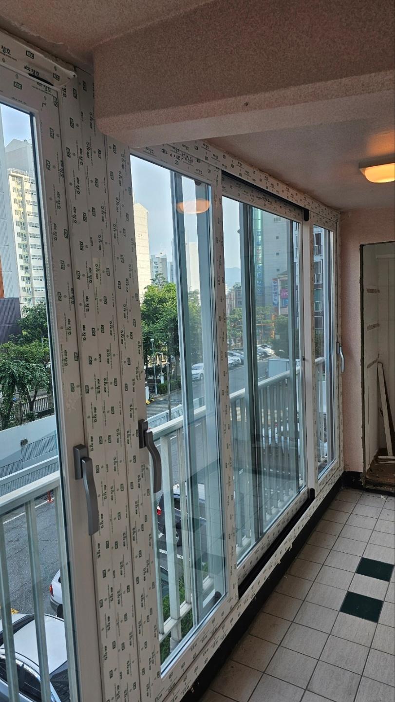 흰색 프레임 슬라이딩 창호가 설치된 발코니 전경