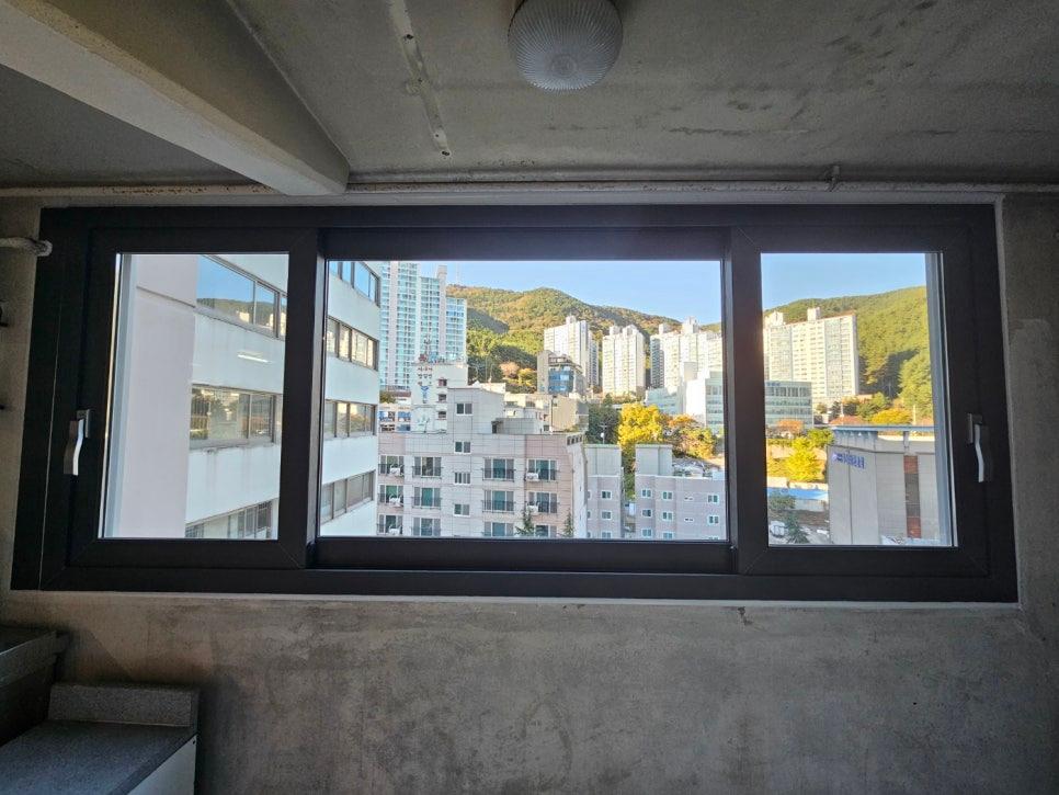콘크리트 벽면과 천장 조명이 보이는 창호 설치면