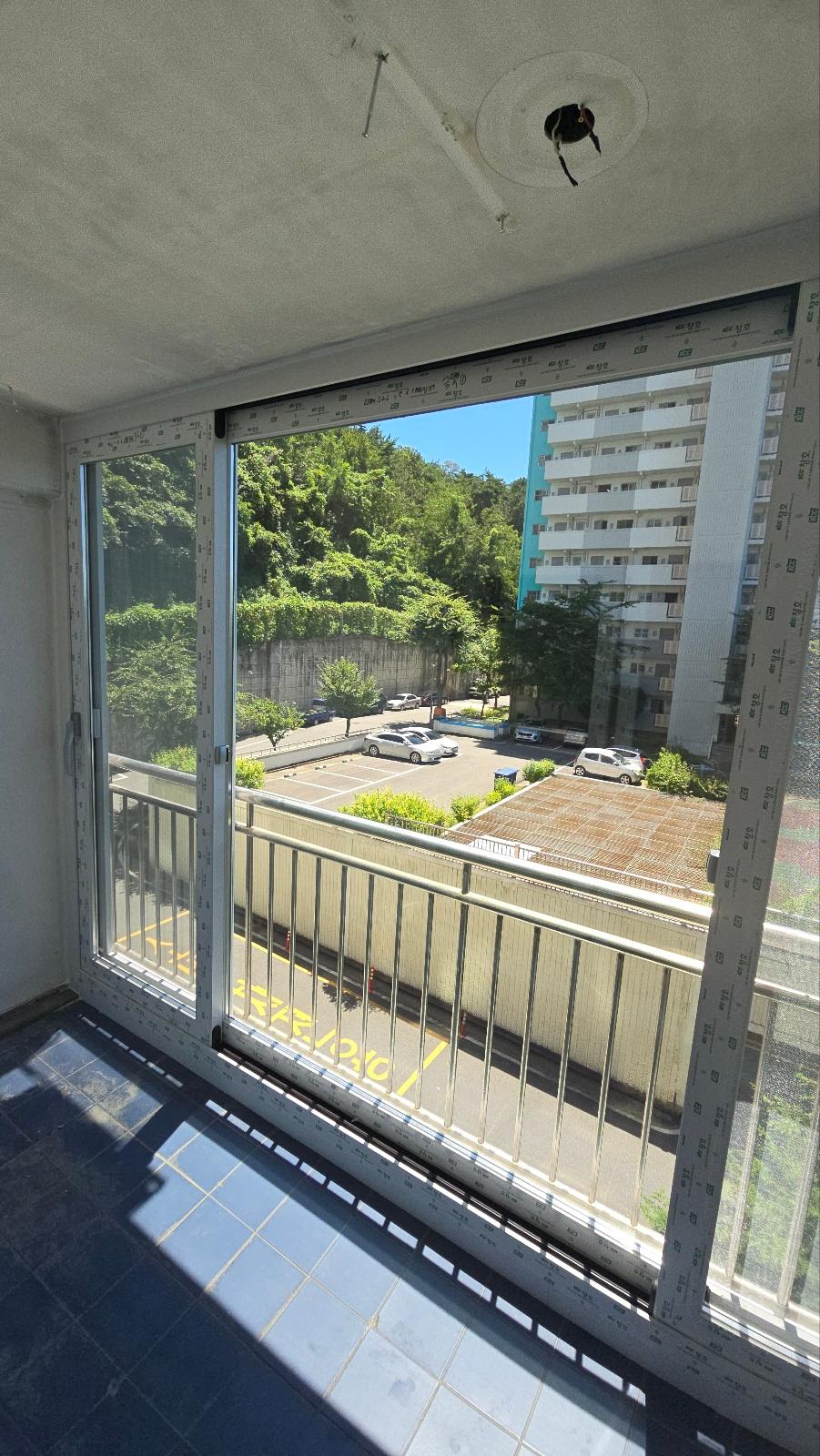파란색 타일 바닥의 발코니와 흰색 슬라이딩 창호