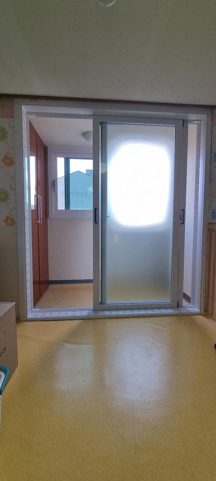 베이지색 마루가 깔린 실내의 슬라이딩 유리문