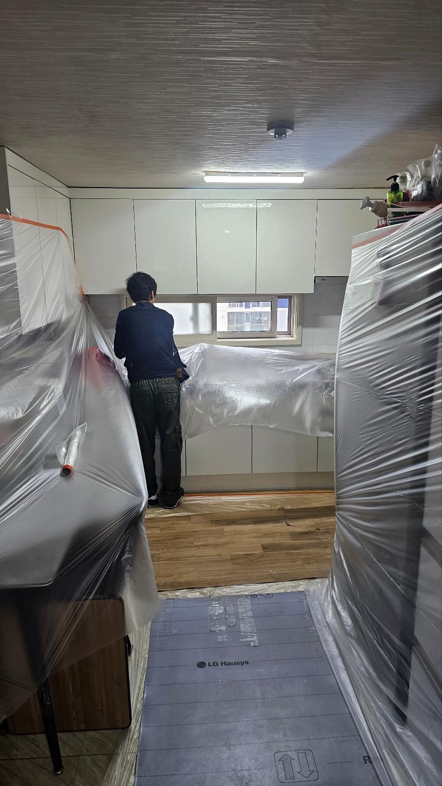보호 필름이 덮인 주방 가구와 바닥