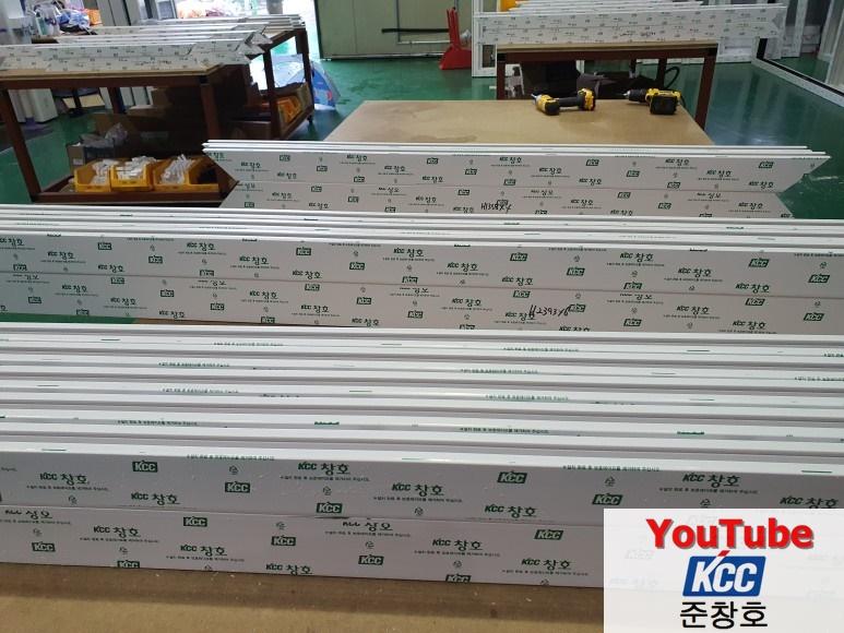 KCC 문구가 인쇄된 흰색 프레임 자재들이 적재된 모습