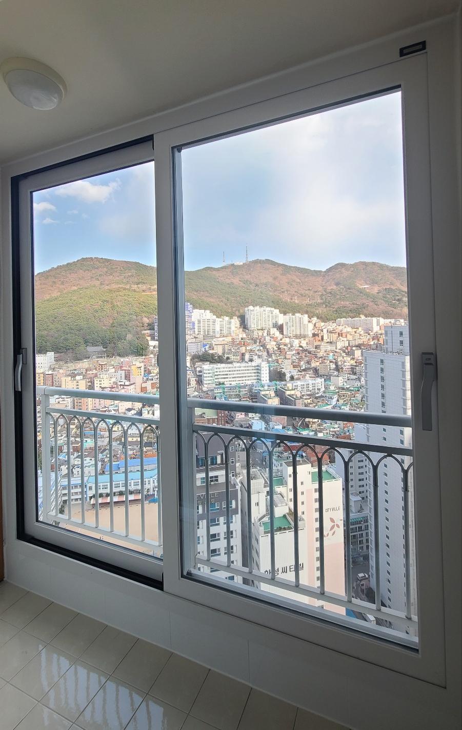 발코니 난간과 외부 산 전경이 보이는 실내 창문
