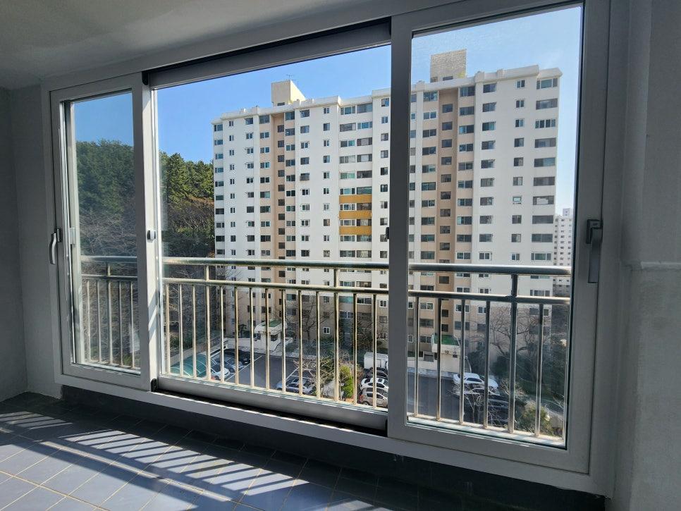 흰색 프레임 창호와 금속 레일 난간이 보이는 발코니
