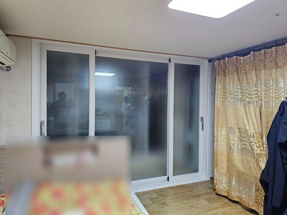베이지색 벽지와 목재 바닥이 보이는 실내 창호 주변