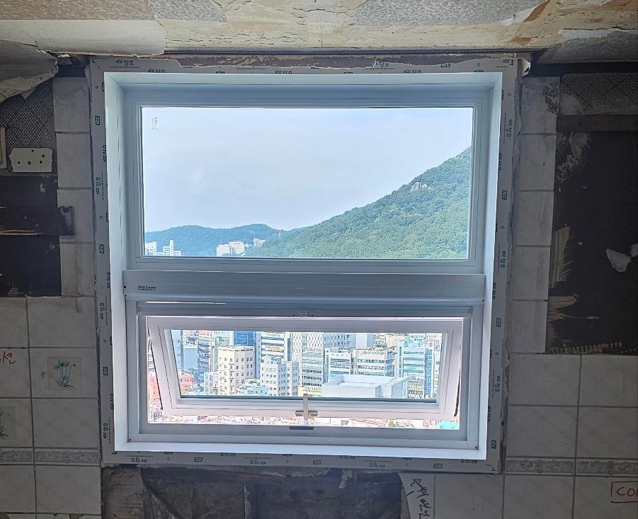 도시 풍경이 보이는 흰색 프레임의 창호 설치 모습