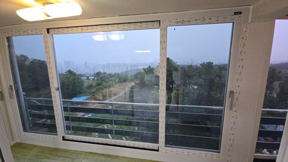 실내에서 바라본 정돈된 화이트 톤의 발코니 창호