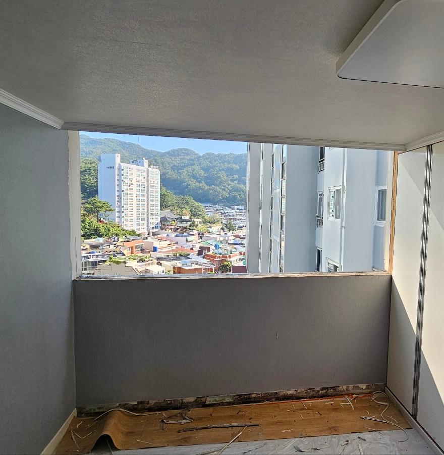 창문 주변 벽면 노출과 바닥 보드 자재가 보이는 상태