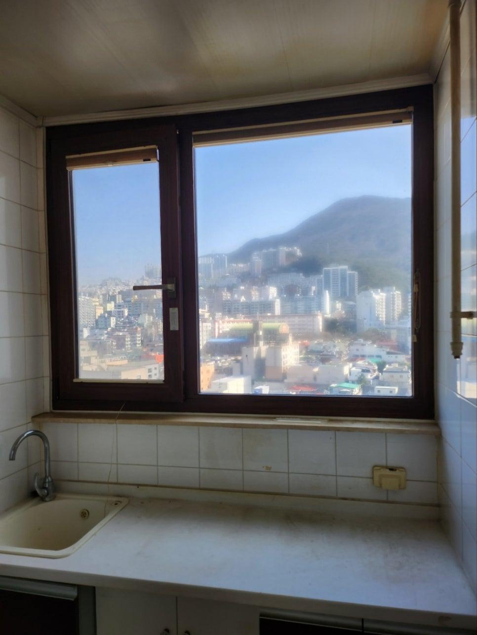 흰색 타일 벽면과 맞닿은 주방 창호의 철거 모습