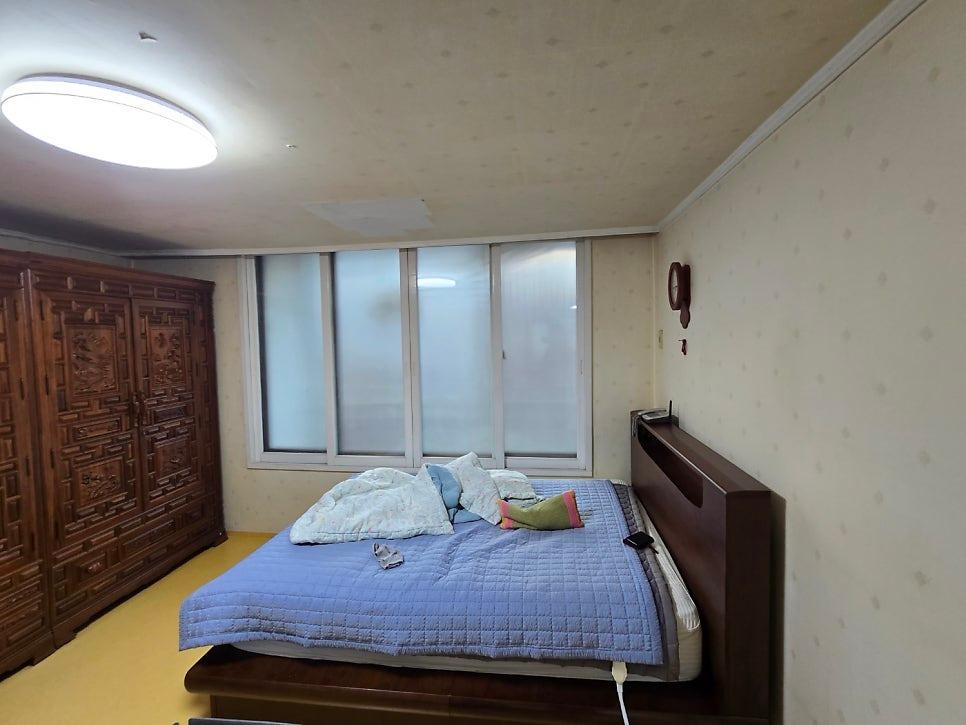 침대와 수납장이 있는 안방의 창호 교체 모습