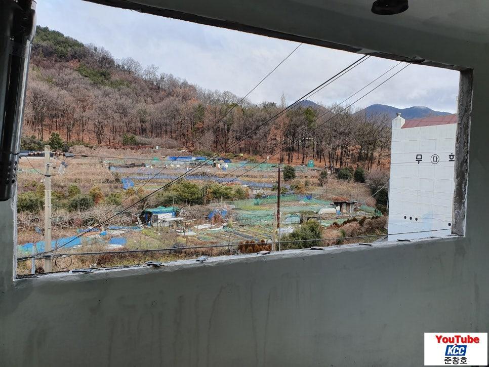 창호를 통해 보이는 산지와 농업 시설 풍경