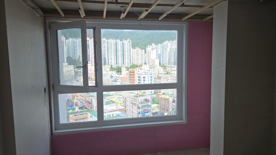 분홍색 벽면과 대비되는 설치 중인 흰색 창호
