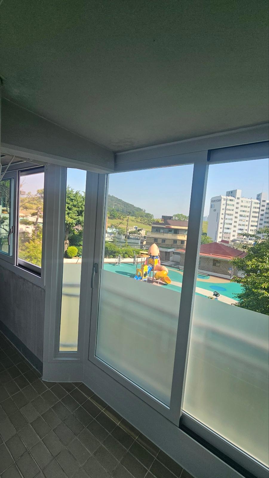 놀이터 풍경이 보이는 발코니의 흰색 프레임 창호