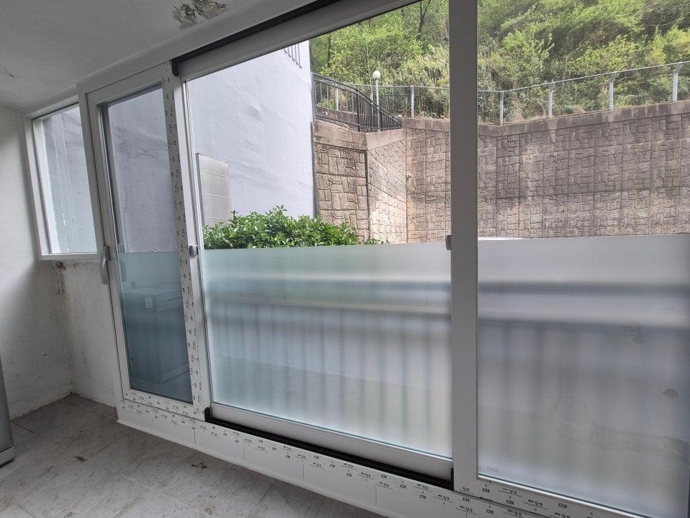 타일 바닥과 흰 벽이 보이는 발코니 창호 시공 모습