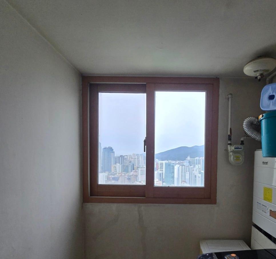 흰 벽면과 갈색 창호 프레임이 맞닿은 근접 모습