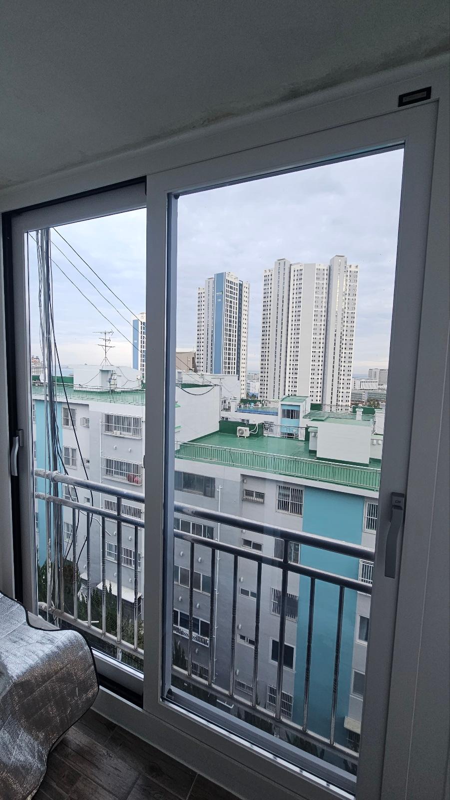 흰색 프레임 슬라이딩 창호와 검은색 난간
