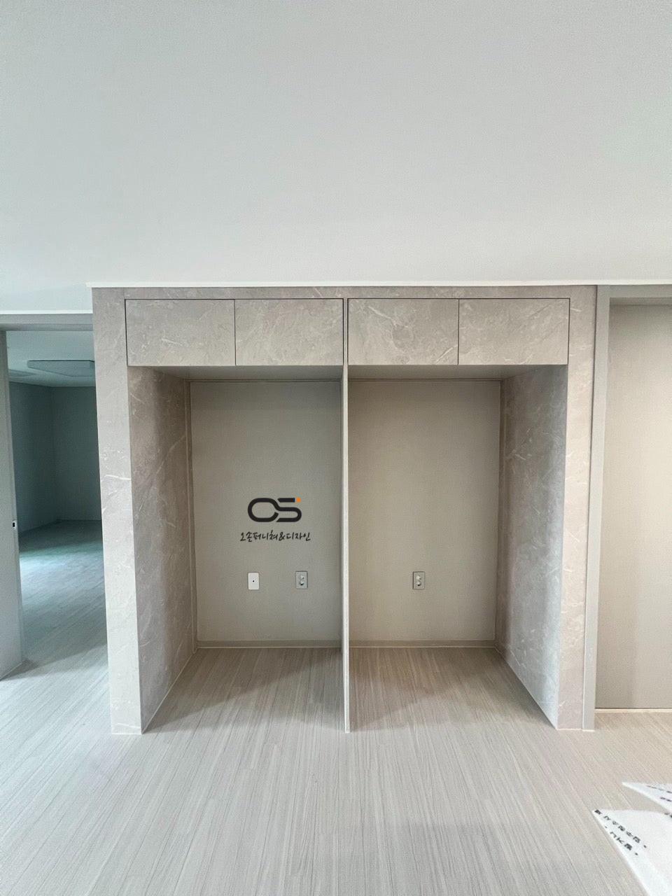 회색 계열 마감의 수납장 구조와 전기 소켓이 보이는 시공 현장