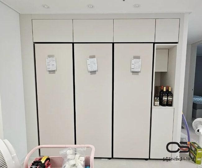 검은색 테두리 수납장과 와인 렉이 마련된 주방
