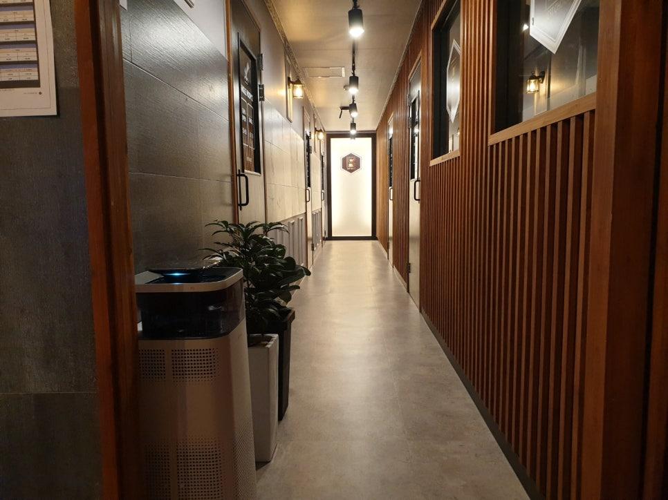우드톤 브라운 슬릿 도어와 회색 벽면의 조화