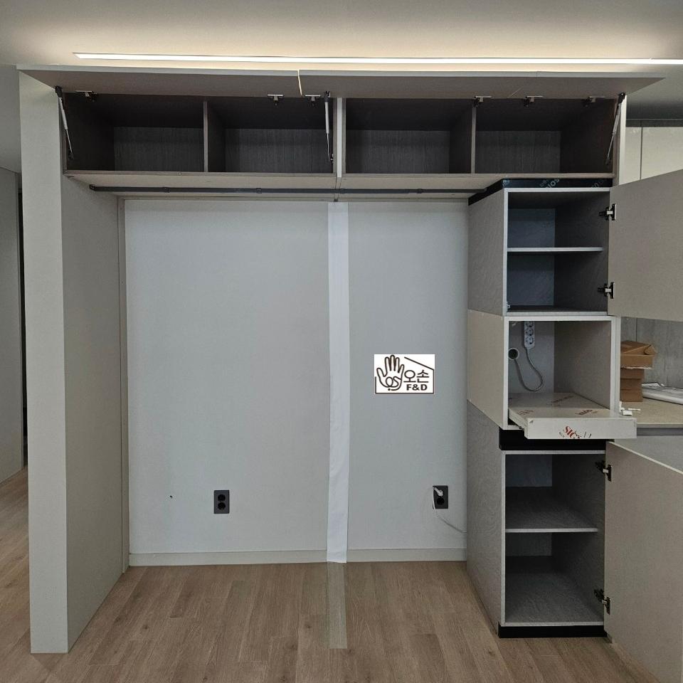 화이트 벽면과 목재 마루가 어우러진 주방 전경