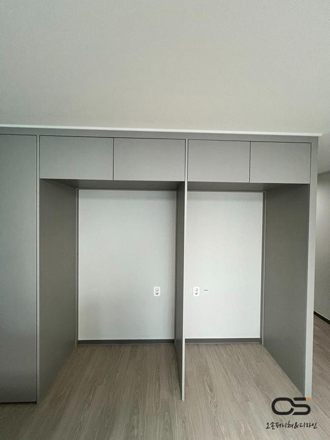 벽면을 채운 회색 수납장과 목재 마루의 조화