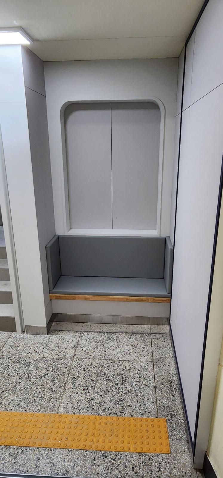 회색 내장 소파와 노란 점무늬 바닥이 있는 복도