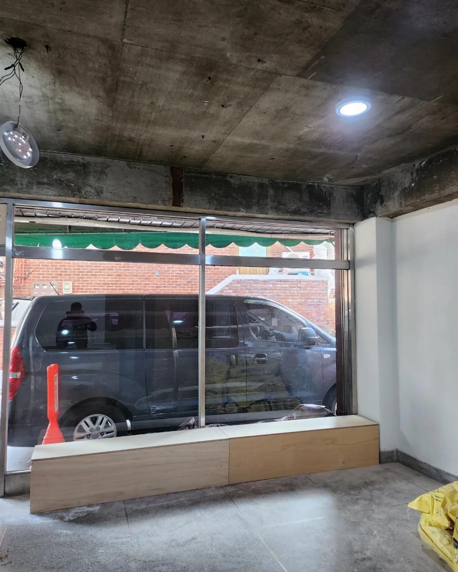유리창과 나무 수납장이 어우러진 타일 바닥 공간