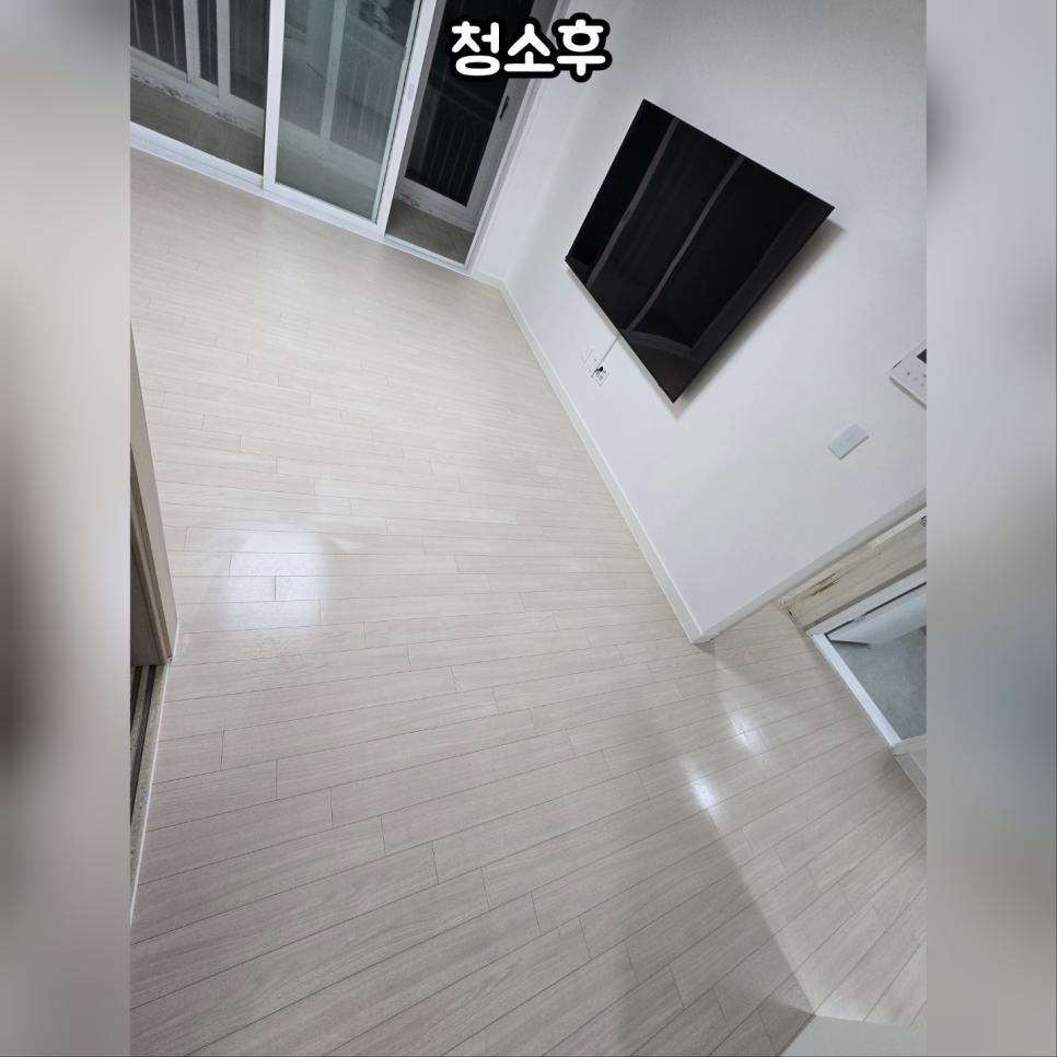 밝은 목재 바닥과 흰 벽의 거실 전경