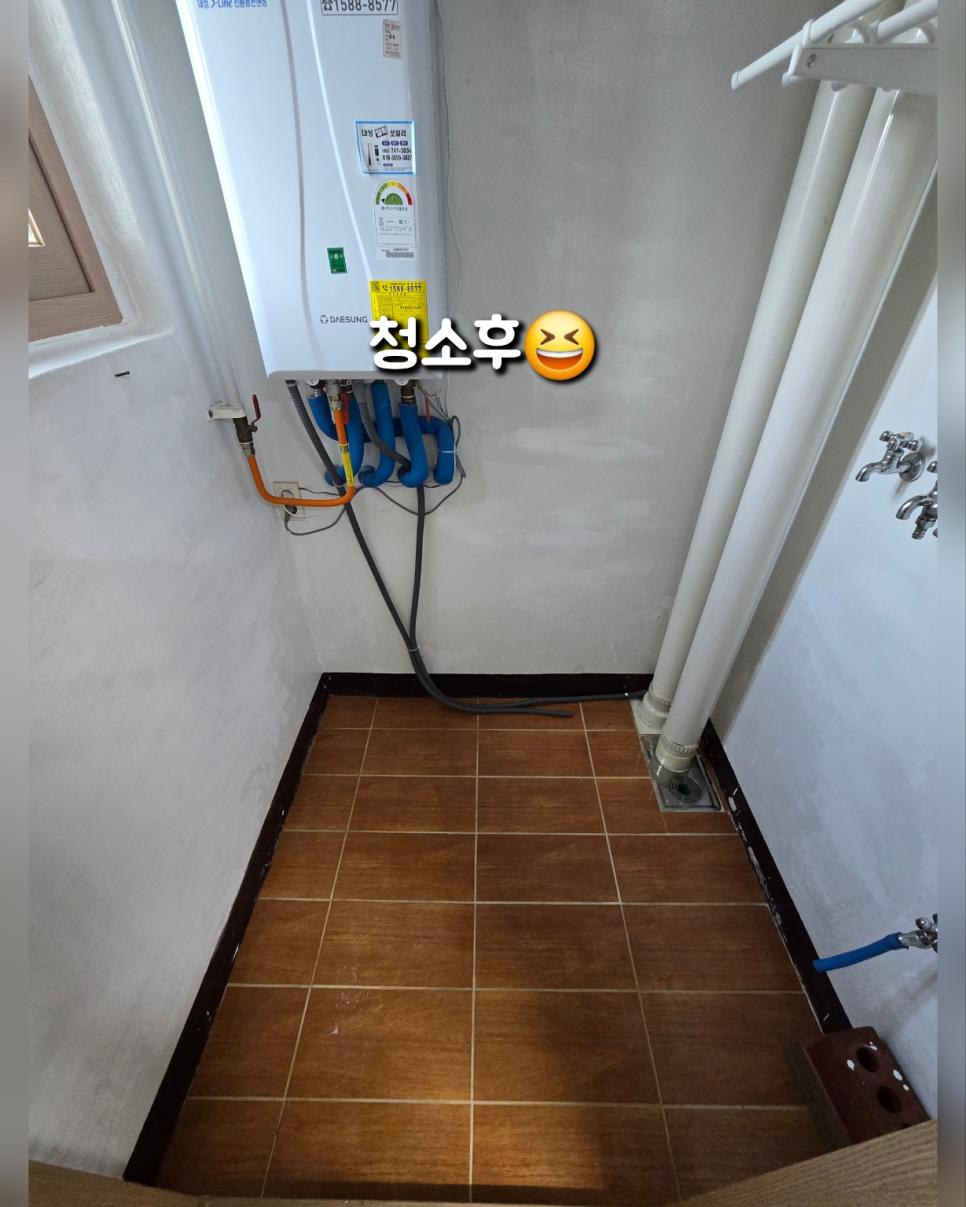 배관과 보일러가 설치된 갈색 타일 바닥 공간